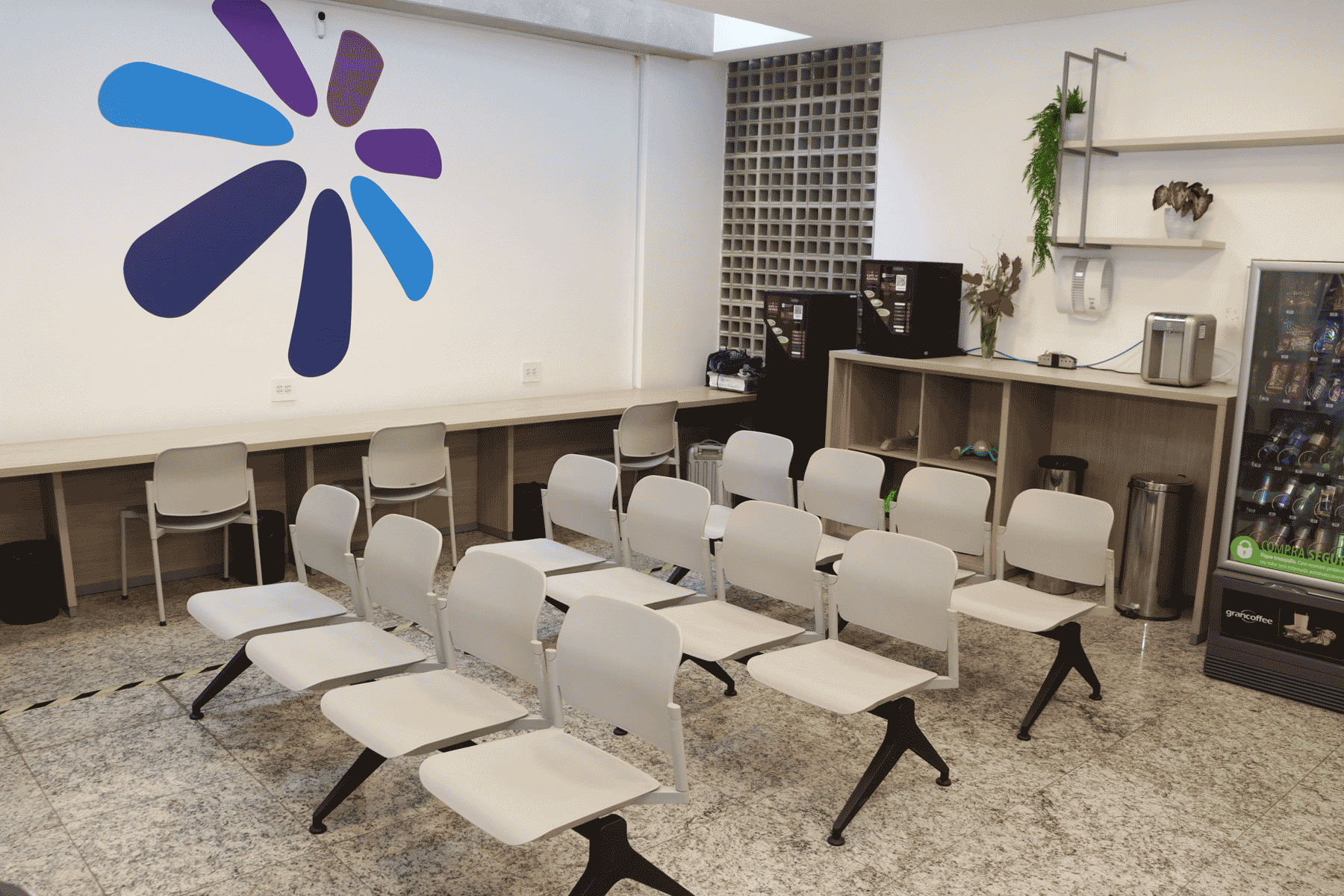 Recepção moderna e acolhedora da Clínica Sphera com recepcionista sorridente atendendo paciente, mostrando ambiente profissional e acessível
